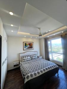 een slaapkamer met een bed en een groot raam bij Elysium Luxury One Bedroom Apartment Opposite Centaurus Mall Islamabad in Islamabad