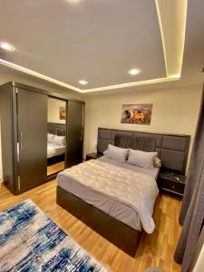 1 dormitorio con 1 cama grande y espejo grande en شاليه فندقى داخل فندق هلنان بورفؤاد Private Apartment Inside Helnan Hotel Port Fouad, en Puerto Saíd