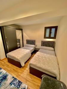 duas camas num quarto com duas janelas em شاليه فندقى داخل فندق هلنان بورفؤاد Private Apartment Inside Helnan Hotel Port Fouad em Port Said