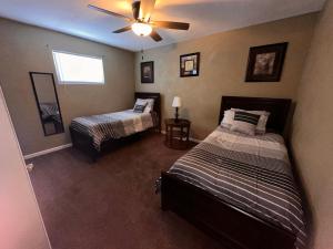 Un dormitorio con dos camas y un ventilador de techo. en A huge Sprawling House on a large lot -15 minutes to St Louis, en Belleville