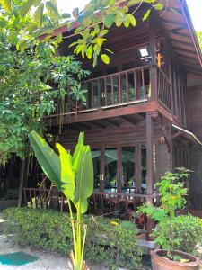 a wooden building with a balcony and a tree at Anda Lipe Resort in Ko Lipe