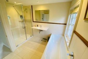 a bathroom with a sink and a shower at Stunning 6-bed country house with heated pool in Headcorn