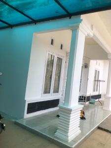 ein blau-weißes Gebäude mit einer Säule in der Unterkunft Homestay Mutiara Syariah in Gadut