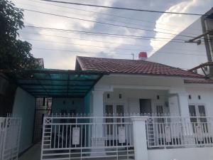 a white house with a white fence in front of it at Homestay Mutiara Syariah in Gadut