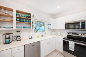 a kitchen with white cabinets and a window at Blue Moon home in Gun Bay