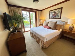 a bedroom with a large bed and a television at Ground floor unit with Private Garden in Kapolei