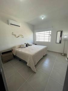 a bedroom with a bed and a window in it at Increíble Casa con alberca y club de playa in Barra Vieja