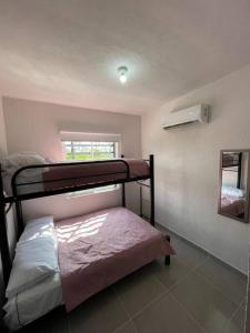 a bedroom with two bunk beds and a window at Increíble Casa con alberca y club de playa in Barra Vieja