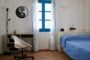 1 dormitorio con cama, escritorio y ventana en Vicky's Studios, en Órmos Aiyialís