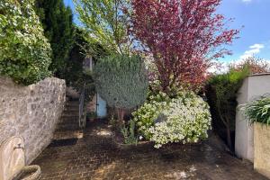 un jardin avec des fleurs et des plantes sur un chemin en briques dans l'établissement Les Yvelines Chavenay - HouseGarden 1ch, à Chavenay
