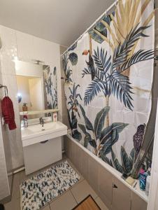 uma casa de banho com um lavatório e uma cortina de chuveiro em Comfort Room I Renewed Duplex em Pantin
