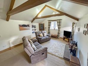 a living room with a couch and a tv at Valley View in Burnsall