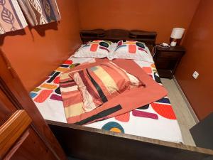 a bed with a quilt on it in a room at residence caramboles in Fort-de-France