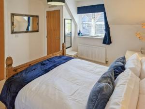 a bedroom with a white bed and a window at Bluebell Lodge in Long Stowe