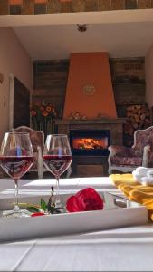 two glasses of wine on a table with a fireplace at Compass in Kavála