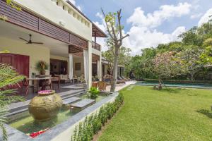 a backyard of a house with a koi pond at Villa Balidamai by Nagisa Bali in Kerobokan