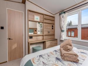 a small bedroom with a bed and a window at Fir Tree Lodge in Aviemore