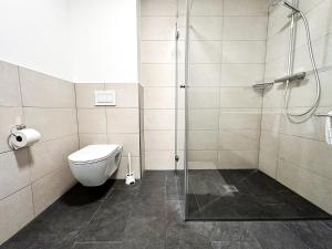 a bathroom with a toilet and a glass shower at FEWO Kübler in Oberstaufen +4 photos
