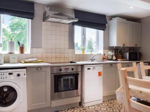 a kitchen with a washing machine and a dishwasher at Brook Farm Cottage in Nantwich