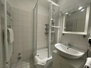 a white bathroom with a sink and a shower at Wiesenweg W01 A in Laboe