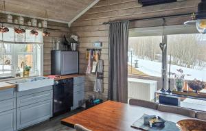 a kitchen with a table and a large window at Beautiful Home In Oppdal With Kitchen in Oppdal