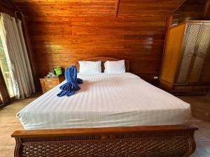 a bedroom with a large bed with wooden walls at Anda Lipe Resort in Ko Lipe