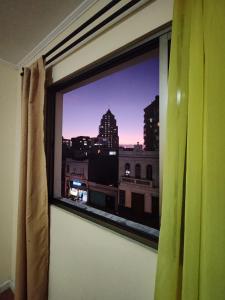 a window with a view of a city skyline at Hotel Brasil in Antofagasta
