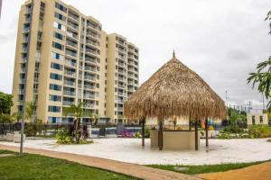 una cabaña de paja frente a un edificio en Apto completo Pto Azul Club House Ven a Descansar en Ricaurte