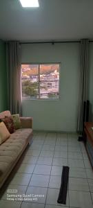a living room with a couch and a window at Apartamento in Belo Horizonte
