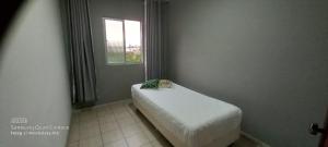 a small bed in a room with a window at Apartamento in Belo Horizonte