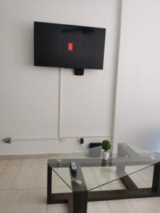 a living room with a tv and a glass coffee table at Ph Torres del Este in Salsipuedes