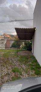 a building with a brown roof on top of a yard at Apartamento in Belo Horizonte