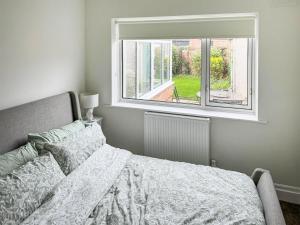 1 dormitorio con cama y ventana en Commonside Cottage en Lytham St Annes