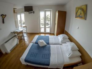 a bedroom with two beds and a desk in it at Apartments Car in Rab