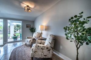 een slaapkamer met een bed en twee stoelen en een plant bij Spectacular Adjoining Homes Waits in Corpus Christi +112 foto's