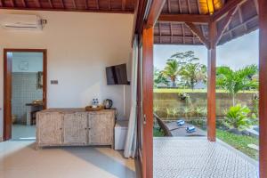 une porte ouverte donnant sur une chambre avec vue sur le jardin. dans l'établissement Sawah Sebatu Villa, à Ubud