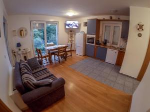 a living room and kitchen with a couch and a table at Apartments Car in Rab