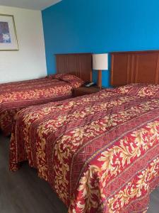 two beds in a hotel room with blue walls at Clover Inn and Suites in Shreveport