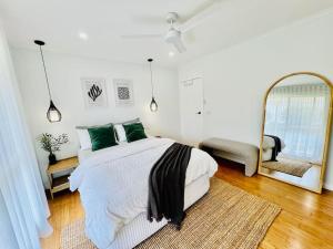 um quarto com uma cama grande e um espelho em Cosy Beach House - Near Hot Springs. em Tootgarook