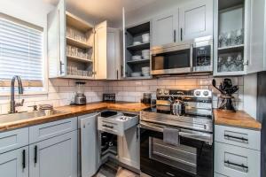 a kitchen with white cabinets and stainless steel appliances at Gulfside Getaway Awaits in Corpus Christi