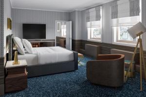 克利夫蘭的住宿－克利夫蘭萬麗酒店，配有一张床和一把椅子的酒店客房