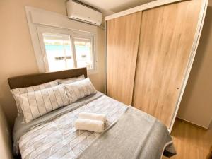 una camera da letto con un letto con copriletto bianco e una finestra di Aconchego do Valle a Gramado