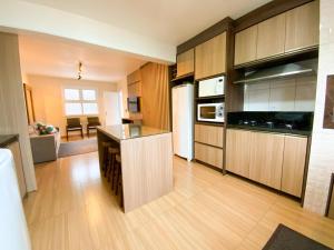 a large kitchen with wooden cabinets and a counter top at Aconchego do Valle in Gramado