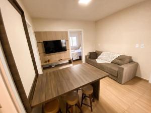 a living room with a table and a couch at Aconchego do Valle in Gramado