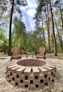 two benches and a fire pit in a park at Szumiąca Sosna in Arciechow