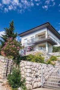 a house on top of a stone wall at Apartments Car in Rab