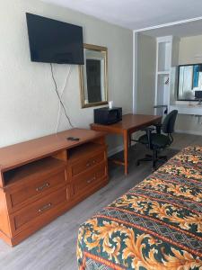 a hotel room with a desk and a bed at Clover Inn and Suites in Shreveport