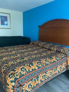 a bed in a bedroom with a blue wall at Clover Inn and Suites in Shreveport