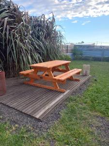 una mesa de picnic de madera en una terraza de madera en LOS MELLIS en Villa Elisa