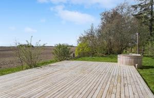a wooden deck with a field in the background at Cozy Home In Sandved With Wifi in Sandved